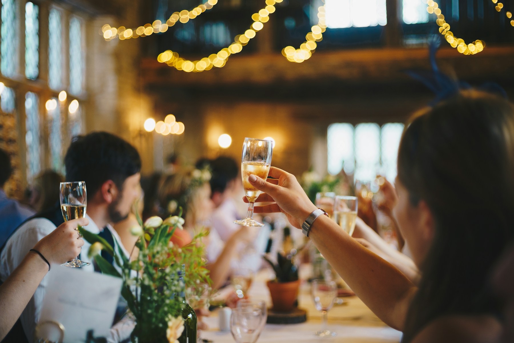 Friends raising a toast together at an outdoor wedding reception