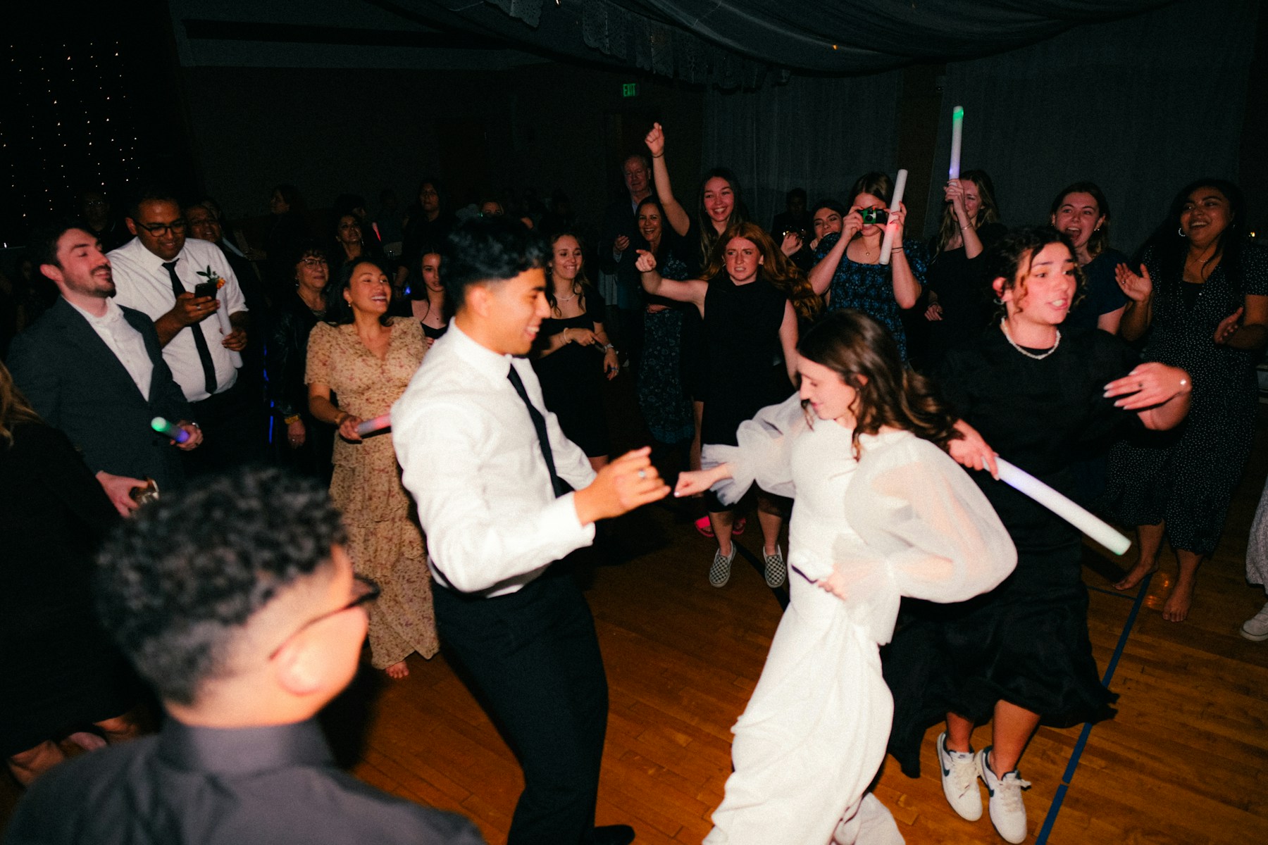 A wedding couple dancing with their guests at their reception